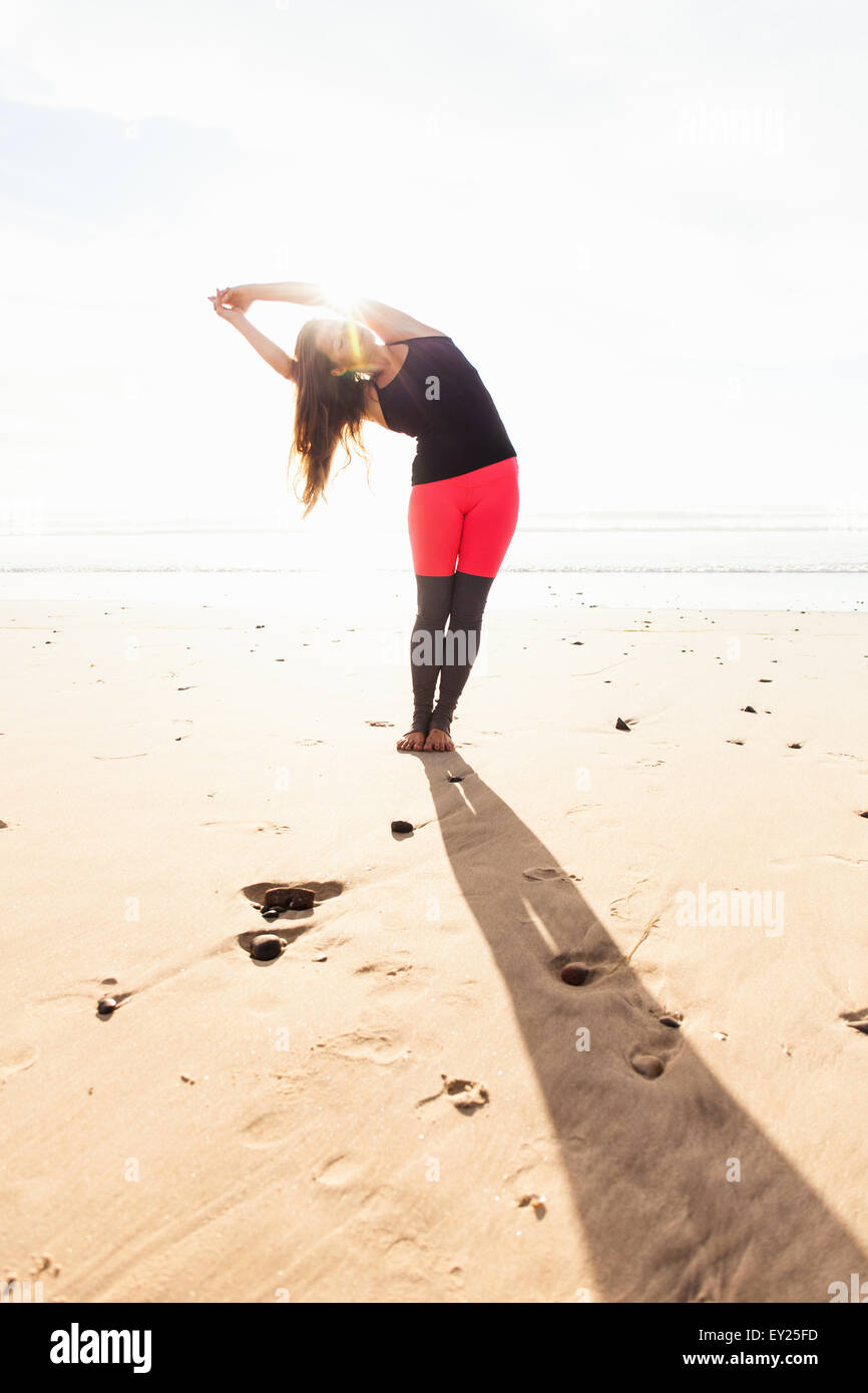 Woman in yoga pose sur plage Banque D'Images