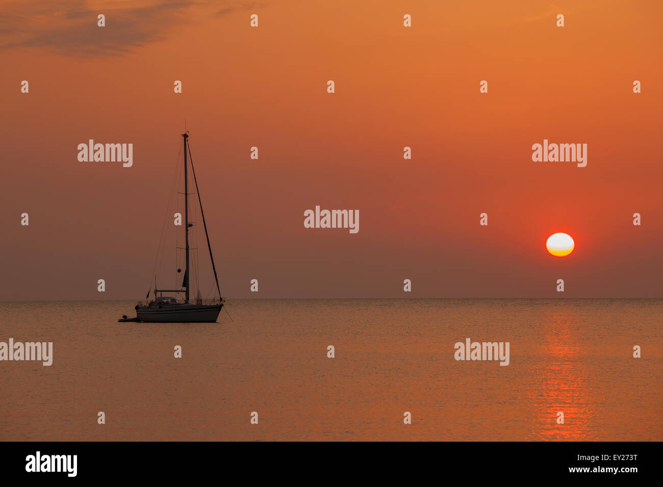 Voile sur la mer au coucher du soleil Banque D'Images