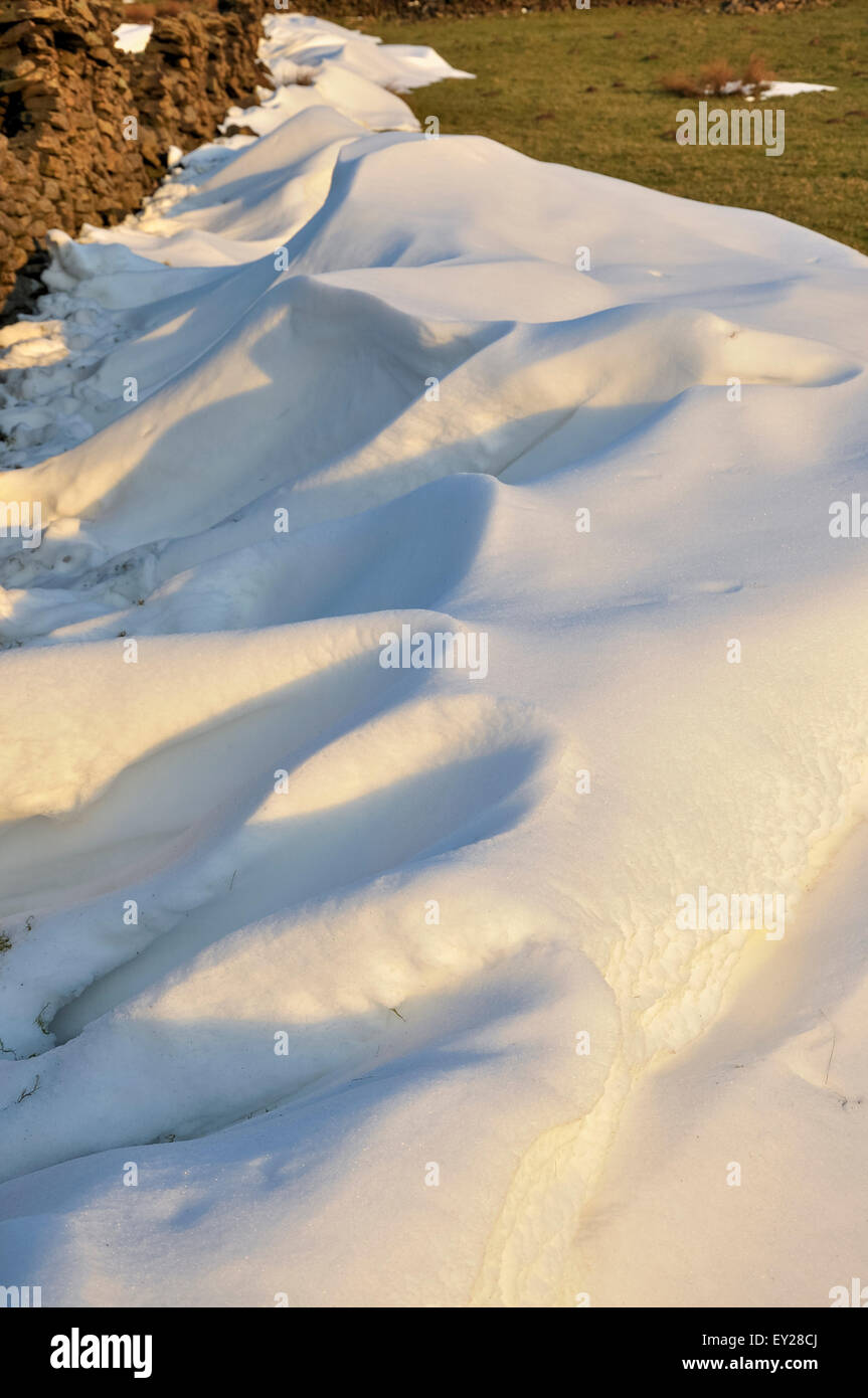 Un banc de neige sur les collines au-dessus de fauche dans le Derbyshire, brillants dans le soleil du soir. Banque D'Images