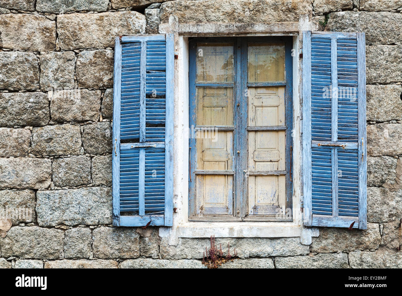 Vieille fenêtre avec volets ouvert bleu en milieu rural ancien mur en pierre gris, texture d'arrière-plan Banque D'Images