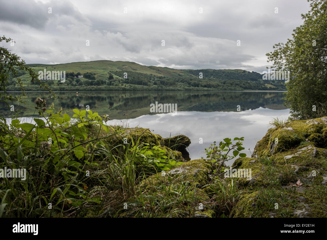 Bala Lake à la recherche sur les pierres aux reflets de nuages dans le Nord du Pays de Galles de l'eau du parc national de Snowdonia UK Juillet 2015 Banque D'Images