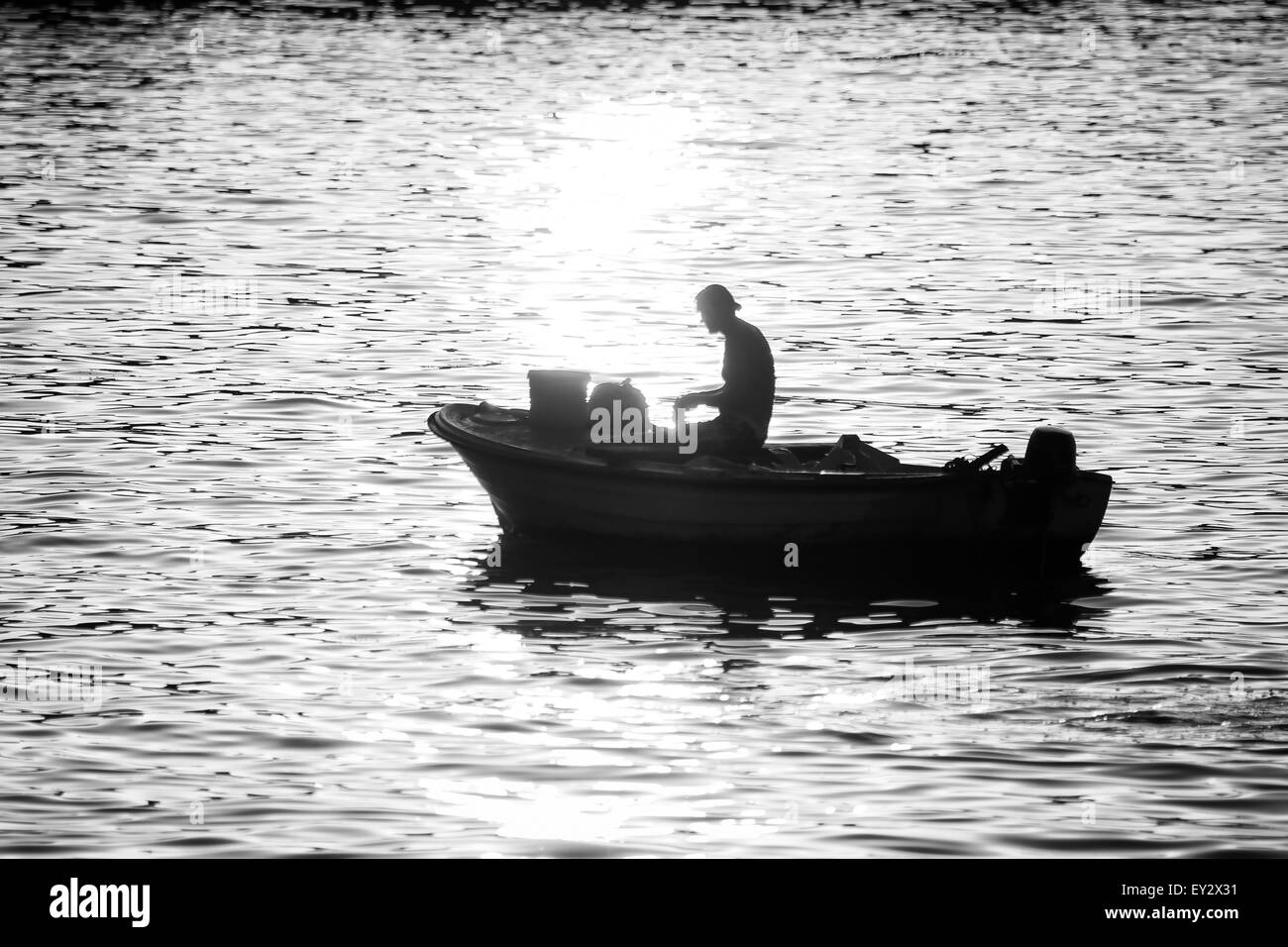 Un pêcheur en bateau à moteur de pêche dans la mer au coucher du soleil sur la région de Rovinj, Croatie. Banque D'Images