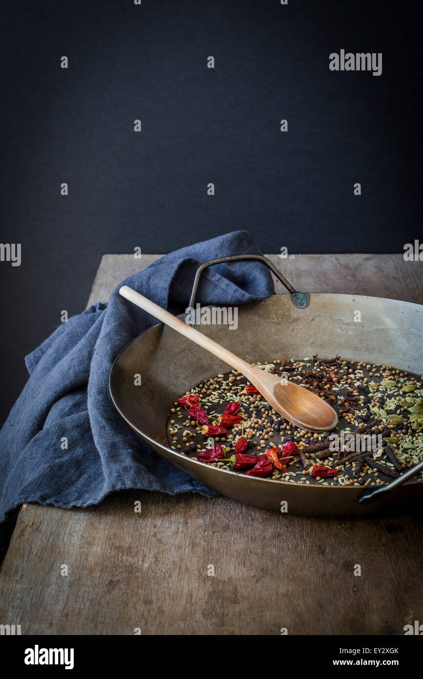 Épices entières préparées pour la cuisson dans une casserole sur la table en bois Banque D'Images