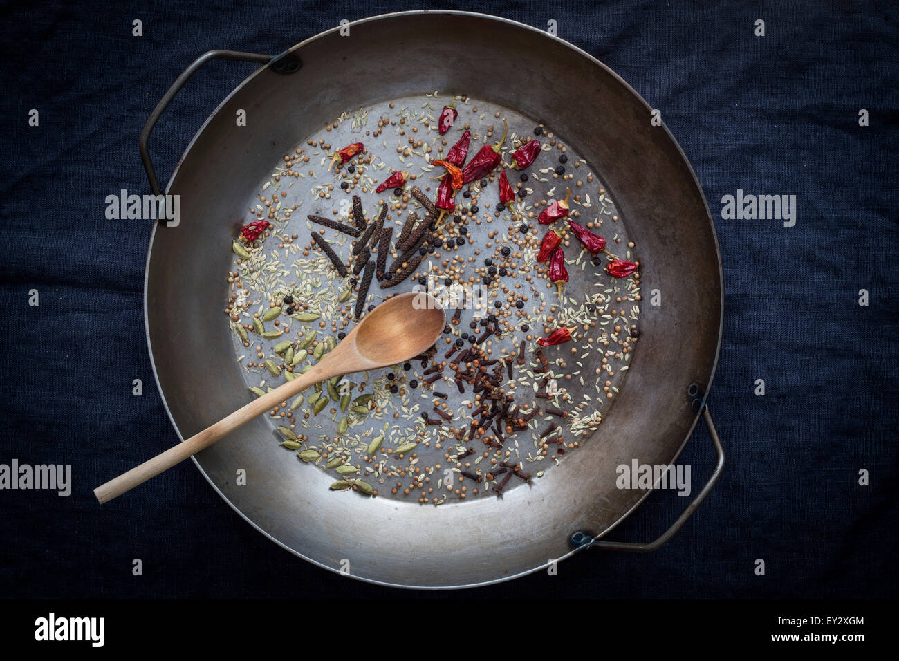 Épices entières préparées pour la cuisson dans une casserole avant d'arrière-plan sombre. Vue d'en haut Banque D'Images