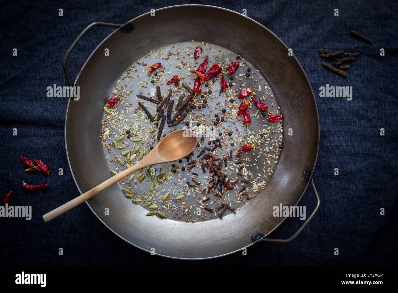 Épices entières préparées pour la cuisson dans une casserole avant d'arrière-plan sombre. Vue d'en haut Banque D'Images