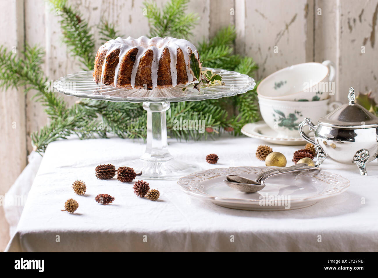 Des gâteaux de Noël avec le glaçage servi avec des branches d'arbre de Noël, vintage art de la table et de la décoration sur table avec languette blanche Banque D'Images