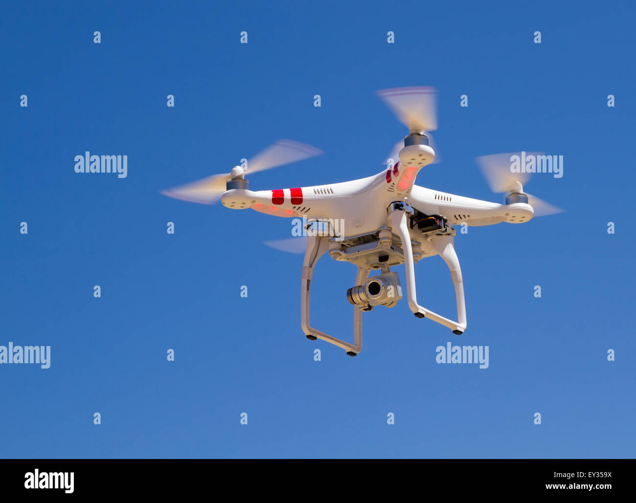 Quadrocopter planant avec un appareil photo contre un ciel bleu Banque D'Images