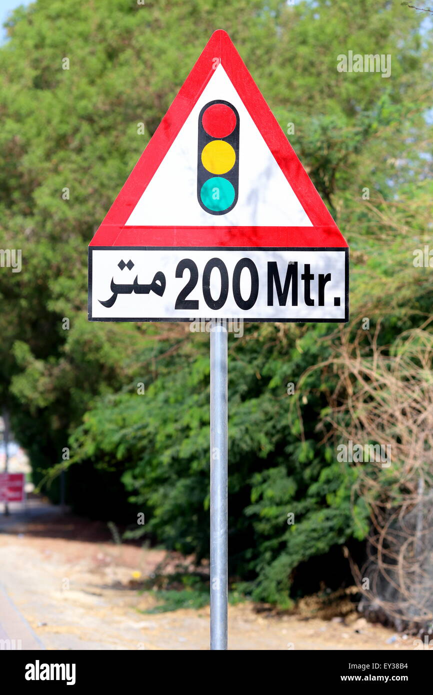 Une signalisation routière en arabe et français avertissement les automobilistes de feux de circulation à 200 mètres plus loin, Royaume de Bahreïn Banque D'Images