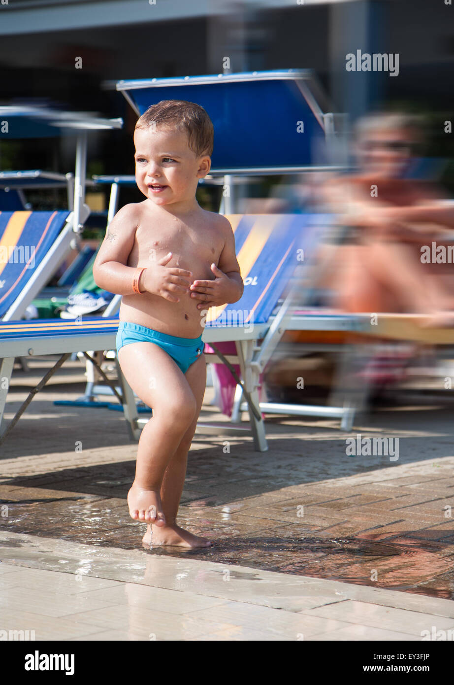 Enfant jouant dans une flaque d'eau dans la piscine Banque D'Images