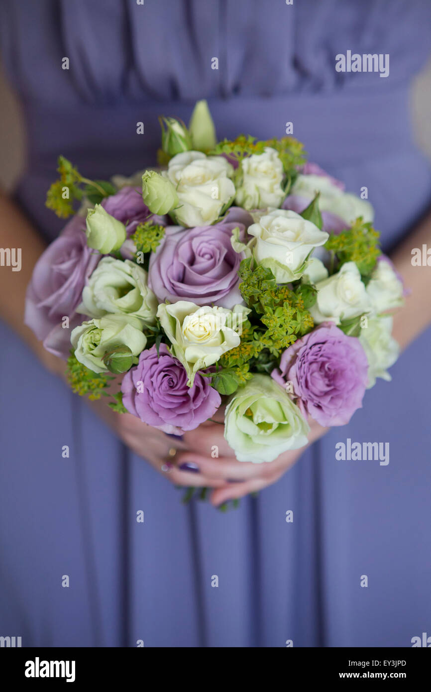 Une femme dans une robe bleue tenant un bouquet de roses. Banque D'Images