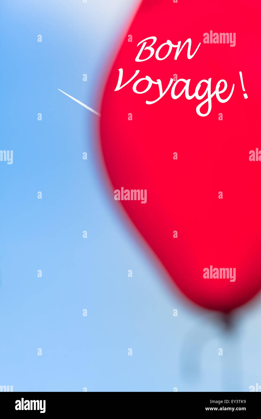 Bon Voyage - Avion traînée et une partie d'un ballon rouge floue avec un message textuel (copie) à l'espace le ciel bleu Banque D'Images