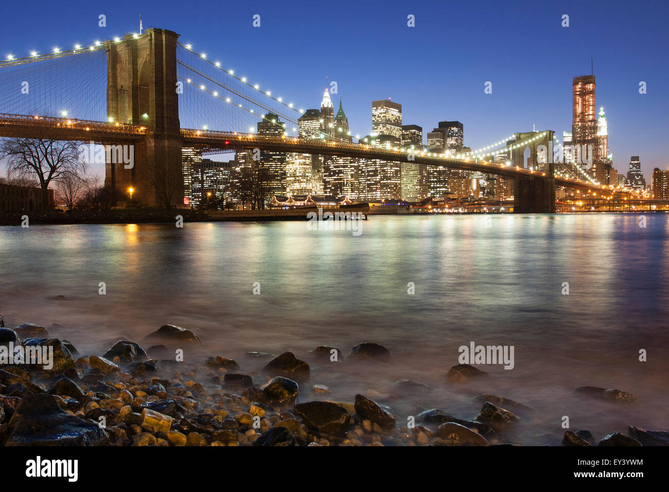 Vue de nuit vers Manhattan de Brooklyn, avec le Pont de Brooklyn enjambant l'East River. Banque D'Images