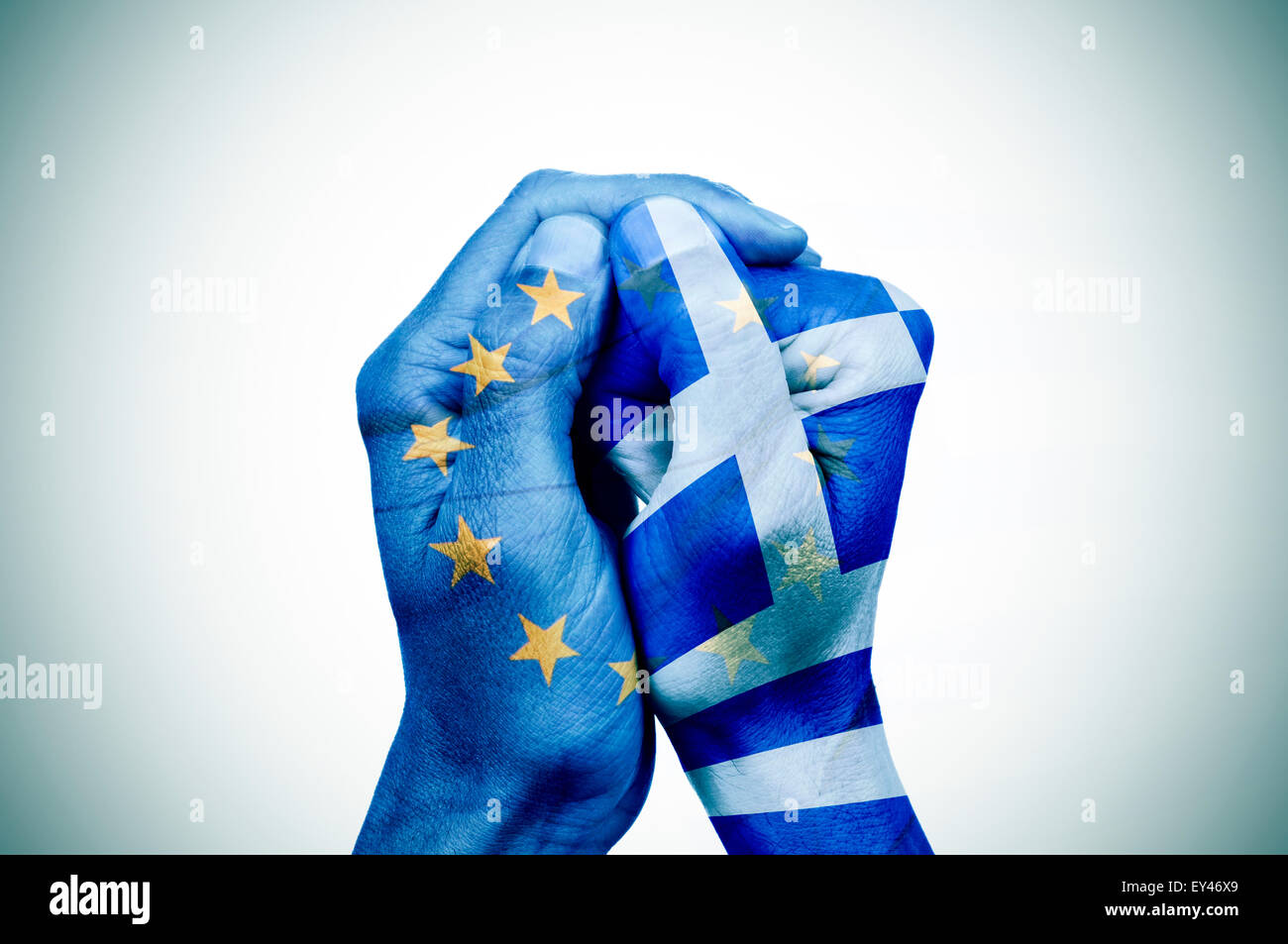 À Motifs de la main le drapeau de la Communauté européenne couvre un autre part, avec le drapeau de la Grèce Banque D'Images