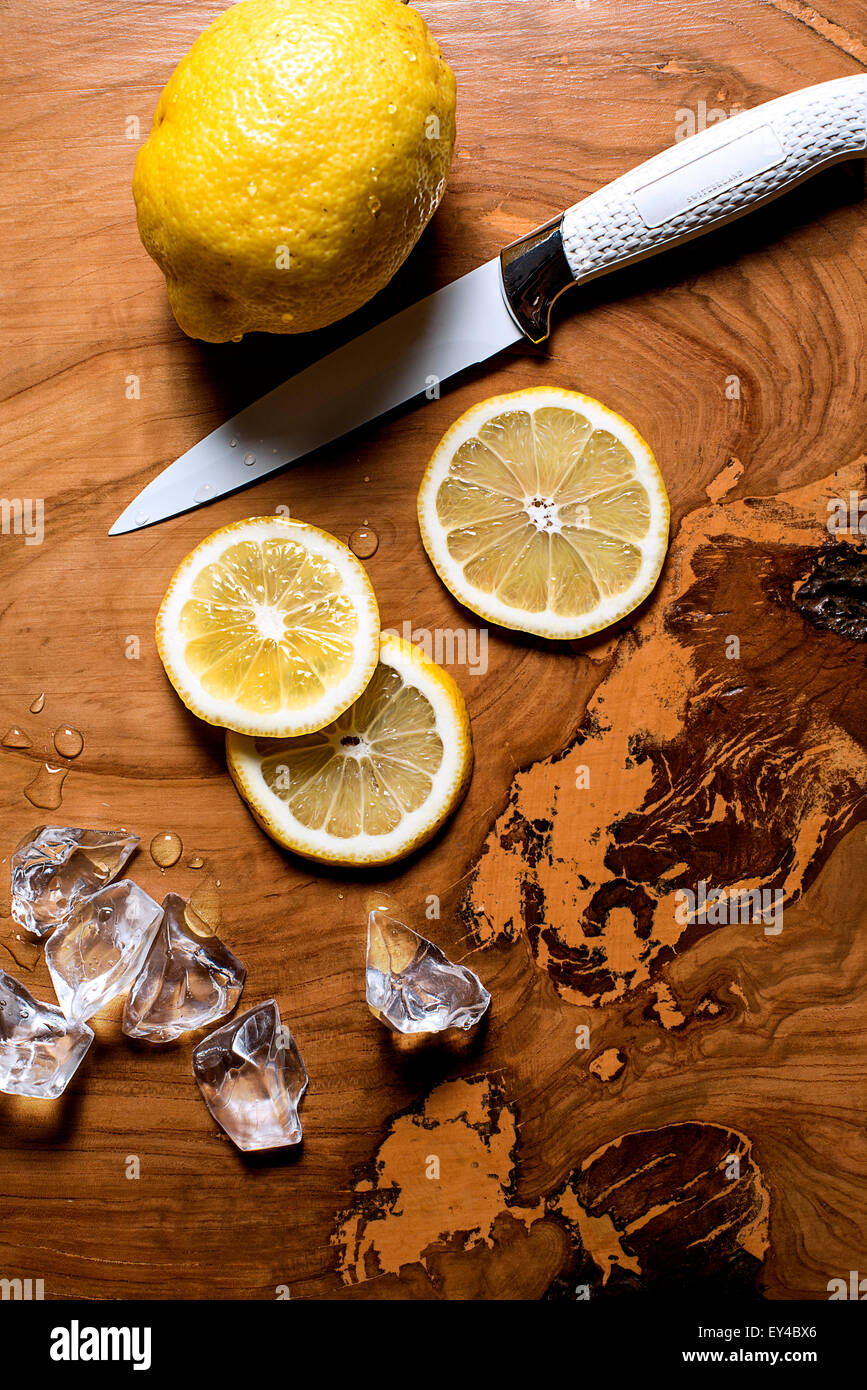 Ensemble de tranches de citron citron, couteau et des cubes de glace sur la table de bois, High Angle View Banque D'Images