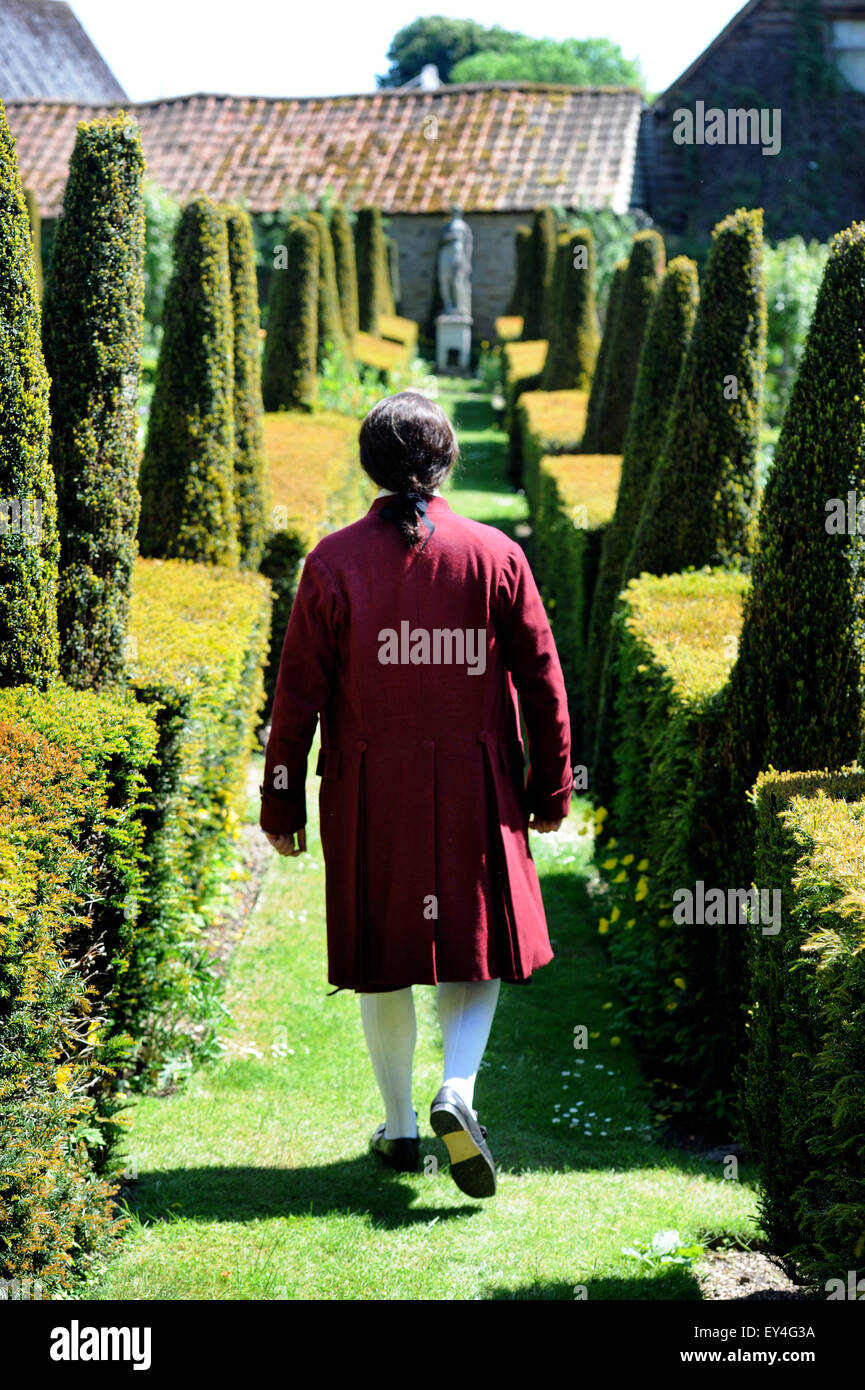 Une chanteuse d'opéra déambule dans le parterre jardin à Garsington Manor Oxfordshire, UK Banque D'Images