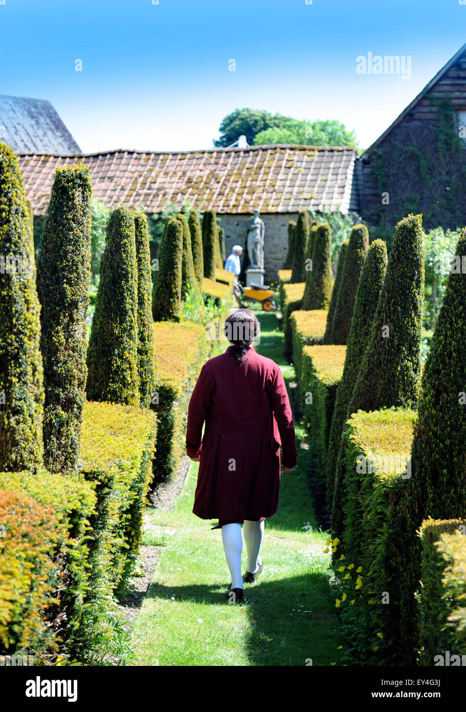 Une chanteuse d'opéra déambule dans le parterre jardin à Garsington Manor Oxfordshire, UK Banque D'Images