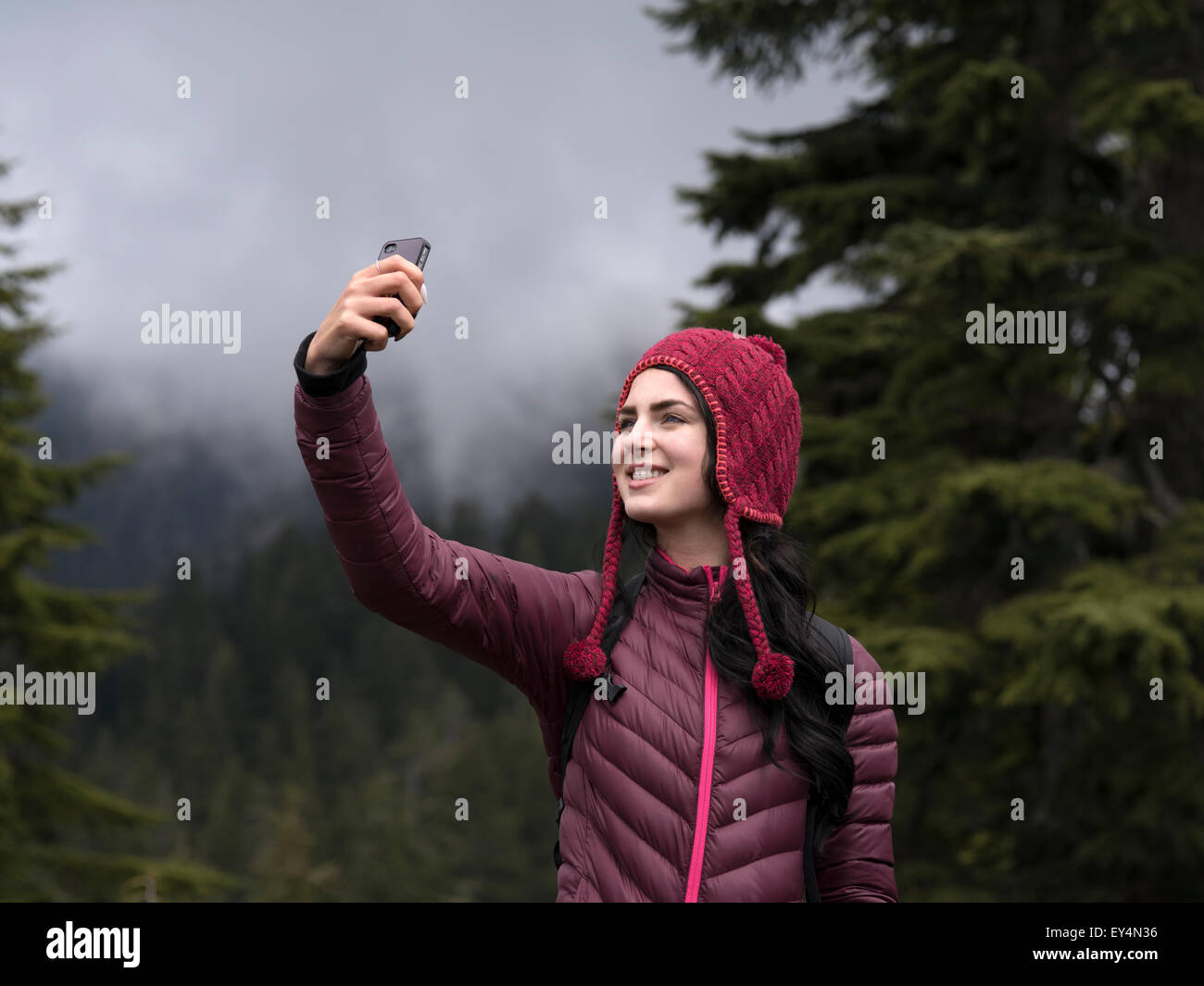 Close up photo d'un smiling caucasian woman en tenant sur la montagne selfies Banque D'Images