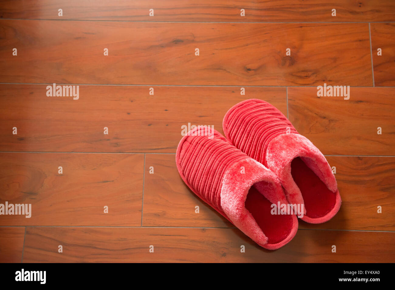 Paire de chaussons rose sur un plancher en bois Banque D'Images