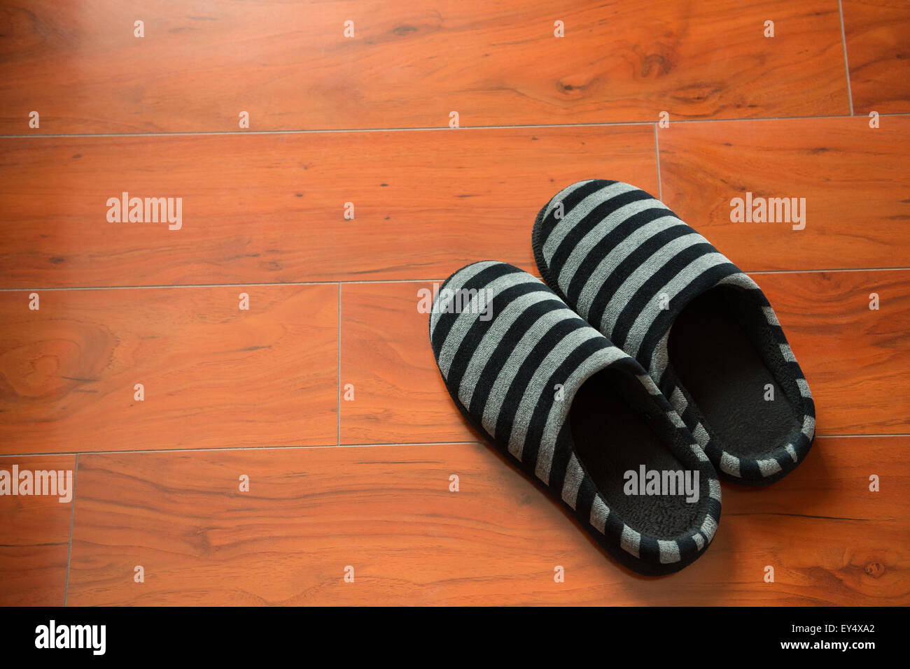 Paire de chaussons noirs sur un sol en bois Banque D'Images