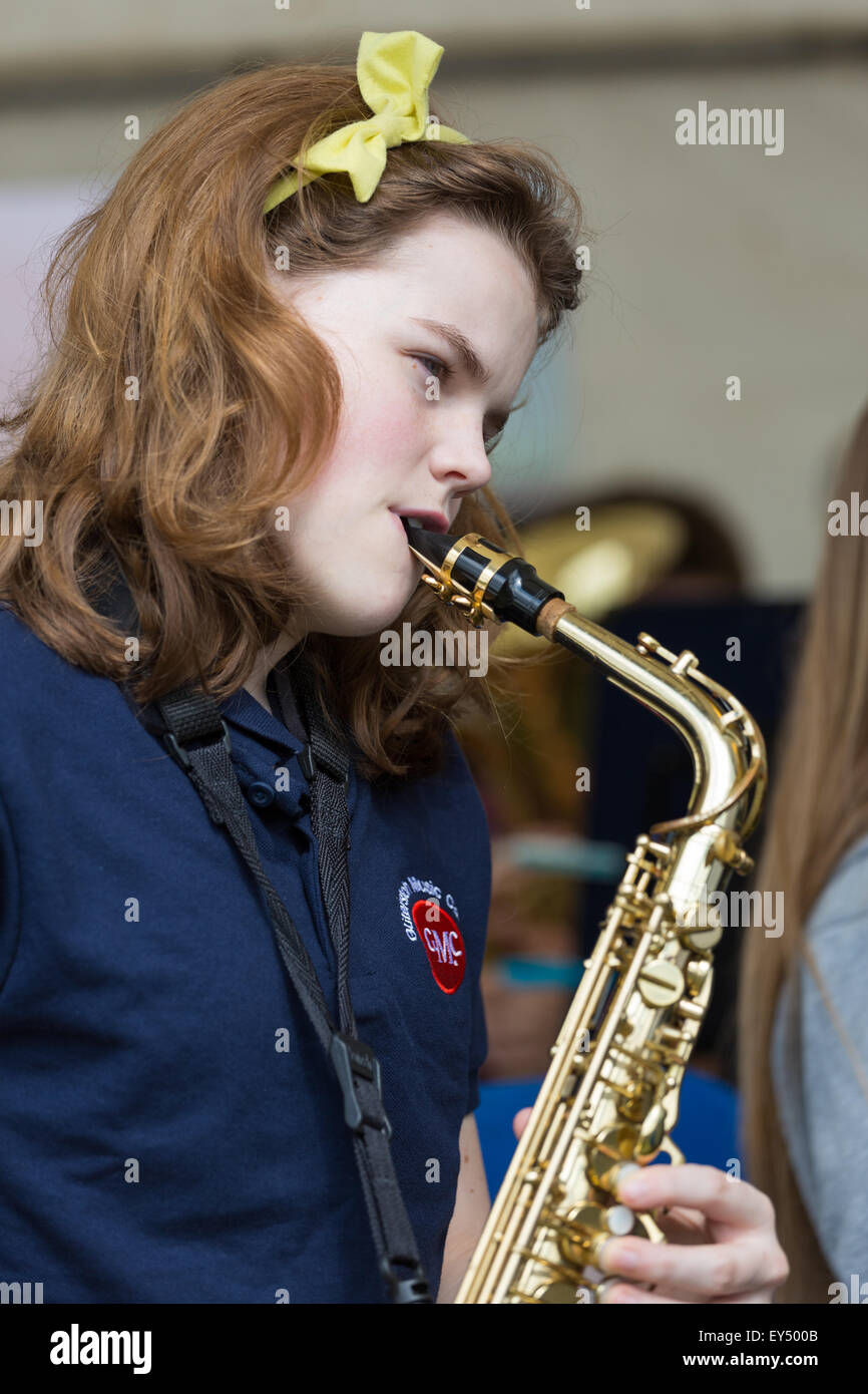 Une jeune femme saxophoniste joue dans un groupe de musique pour la jeunesse / bande / orchestre Banque D'Images