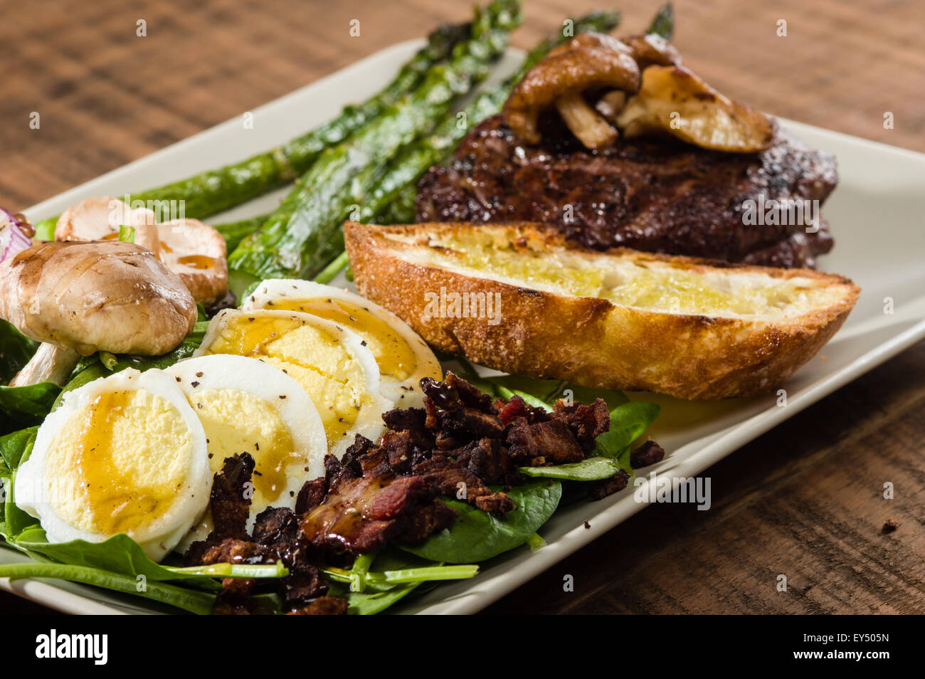Steak et salade d'épinards avec oignons et champignons Banque D'Images