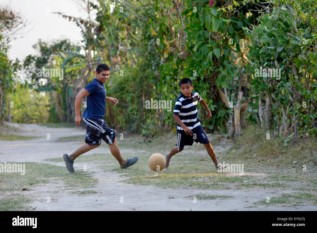 Les adolescents jouent au football sur un terrain de football, des bidonvilles Colonia Monseñor Romero, District Itália, San Salvador, El Salvador Banque D'Images