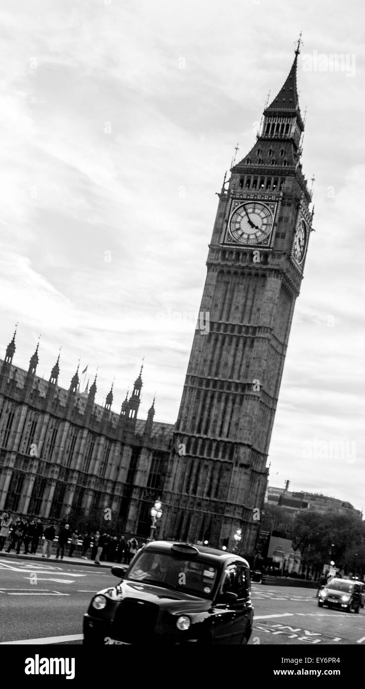 Taxi noir passant devant les Chambres du Parlement et Big Ben Banque D'Images
