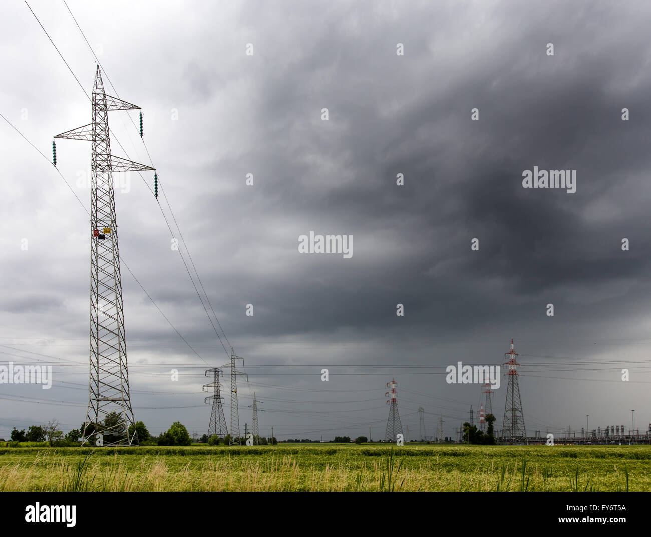 Pylônes de tension dans un champ de blé pendant un orage Banque D'Images