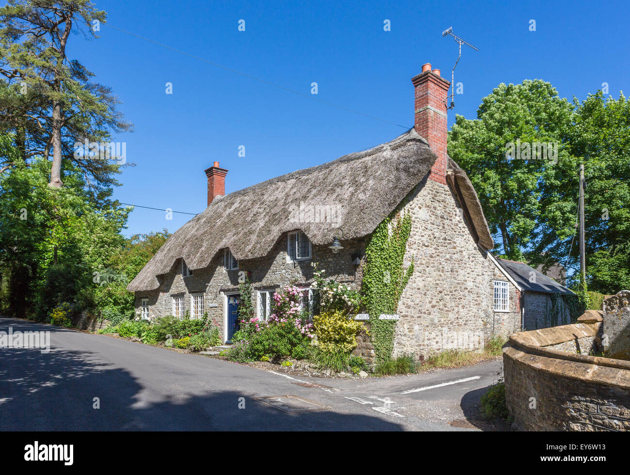 Jolie maison en pierre au toit de chaume, Tess Cottage, Evershot, un petit village dans le Dorset, dans le sud de l'Angleterre, en été avec ciel bleu Banque D'Images