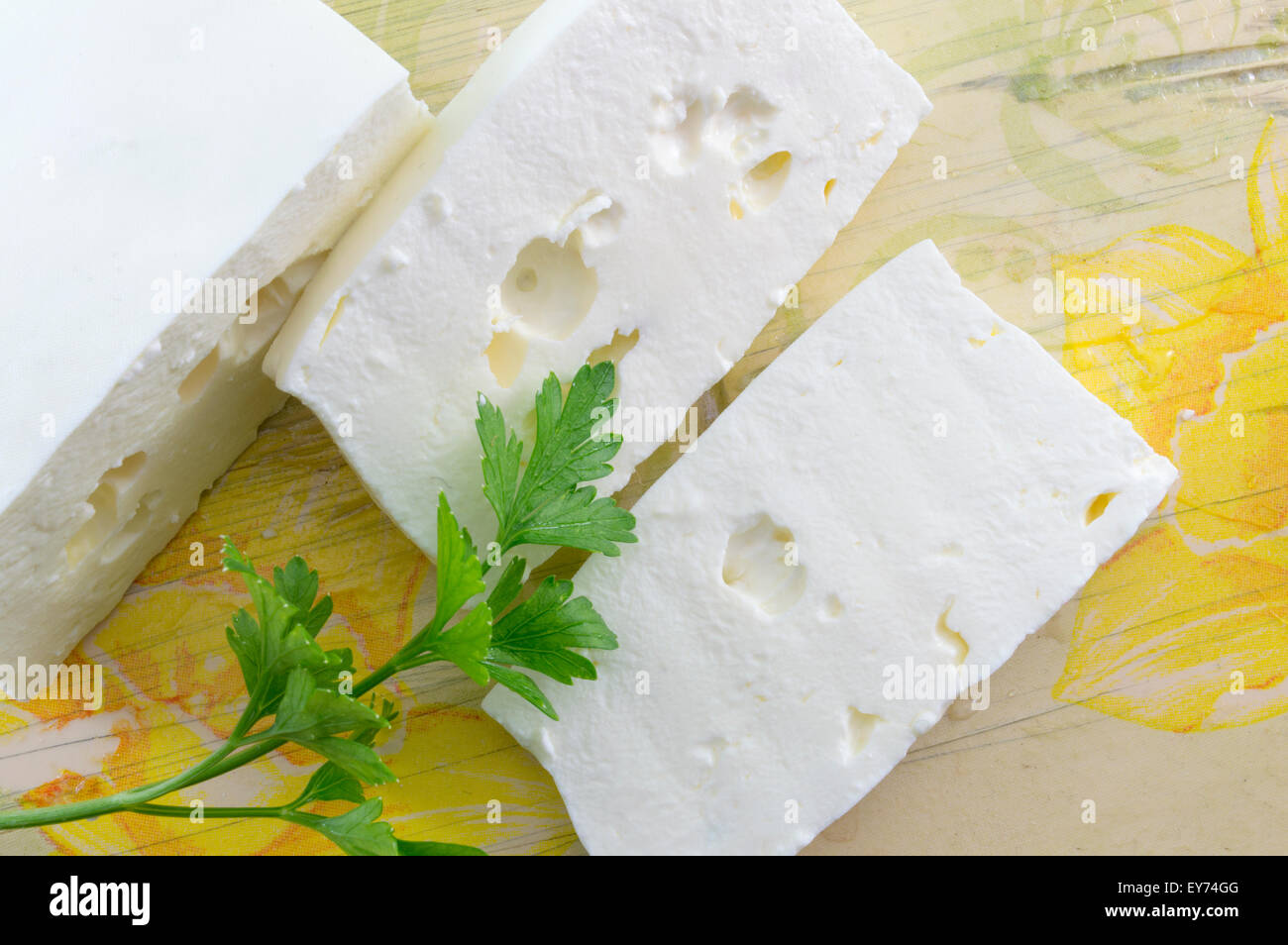 Des tranches de fromage blanc et de persil sur une table décorée de découpage Banque D'Images