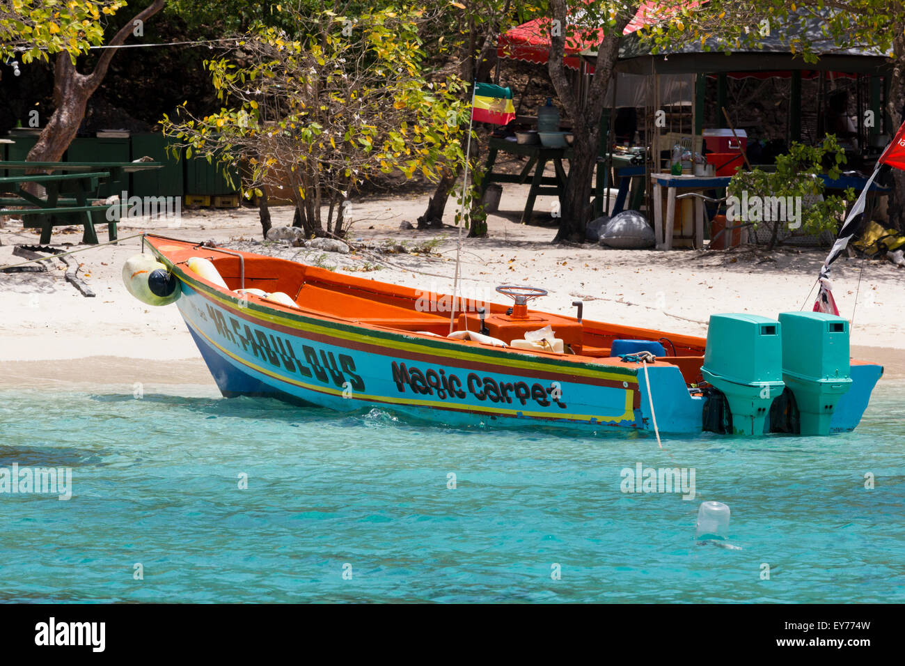 'Mr. Fabulous' ; Water Taxi amarré sur une plage tranquille à Petit bateau avec la mer turquoise des Caraïbes, Tobago Cays, Grenadines. Banque D'Images