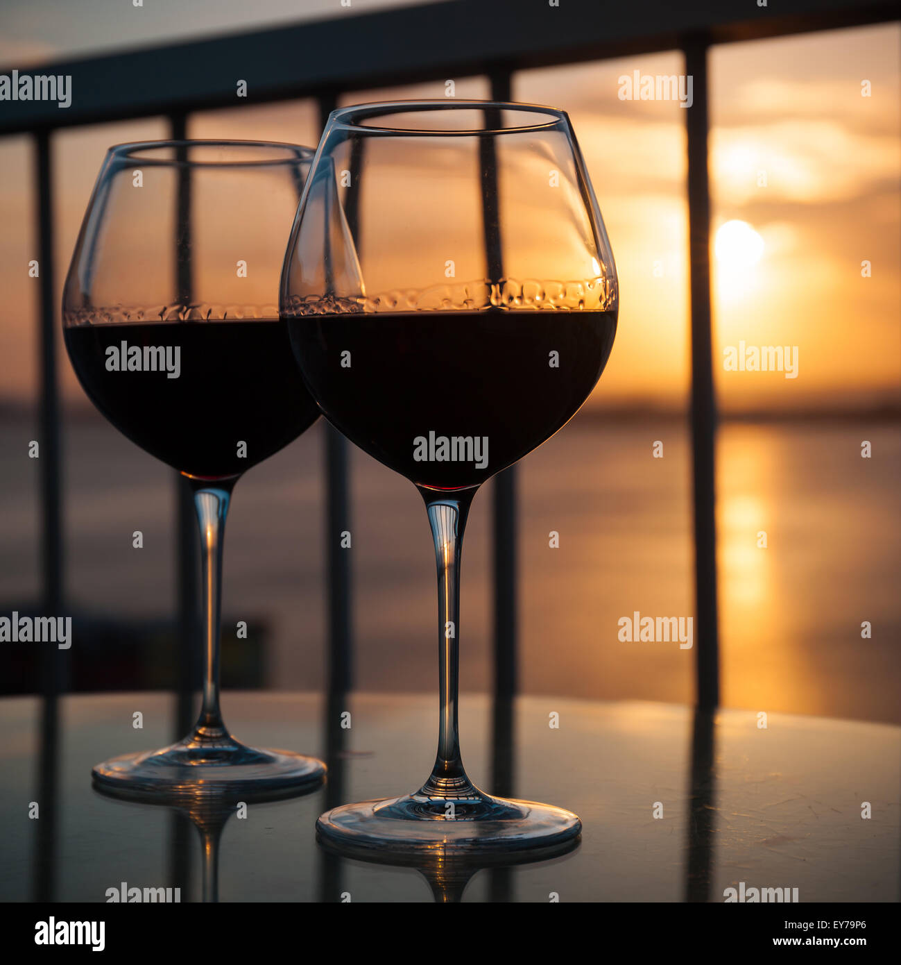 Deux verres de vin rouge en face du soleil couchant. Balcon avec vue sur la mer des Caraïbes contexte Banque D'Images
