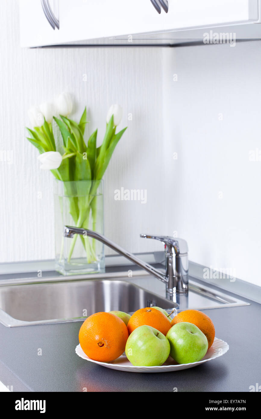 Mode de vie sain, les pommes et oranges en cuisine intérieur blanc Banque D'Images