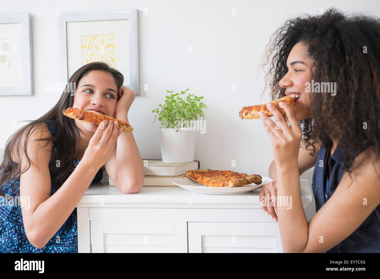 Adolescentes (14-15, 16-17) eating pizza Banque D'Images