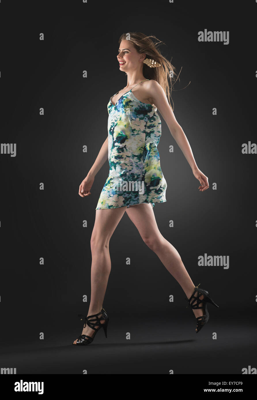 Studio shot of young woman walking Banque D'Images