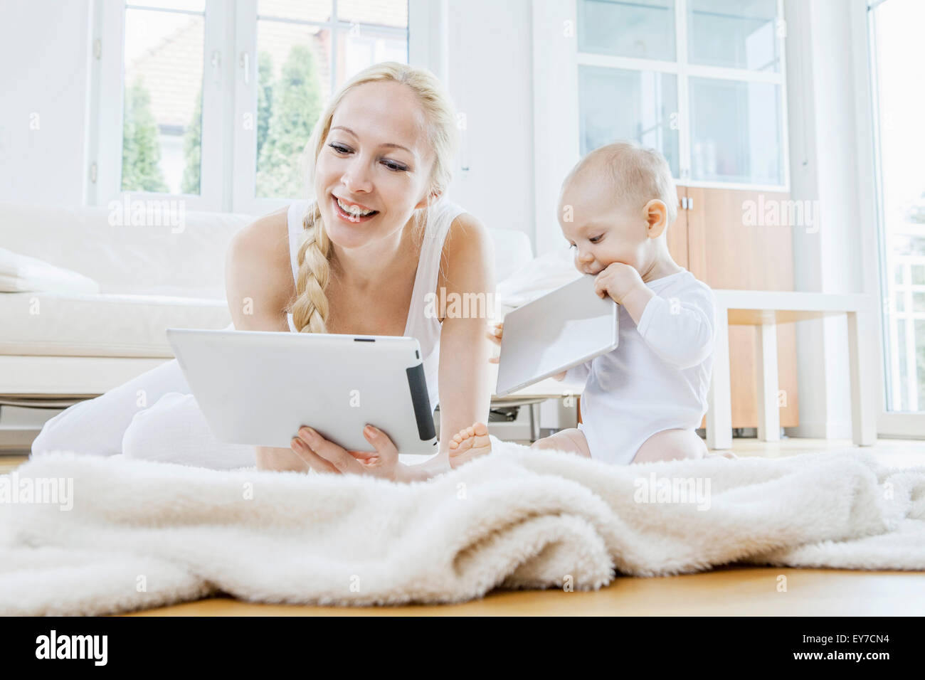 Mère avec tablette numérique aux côtés de bébé Banque D'Images
