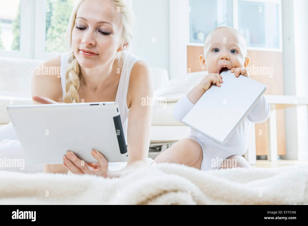 Mère avec tablette numérique aux côtés de bébé Banque D'Images