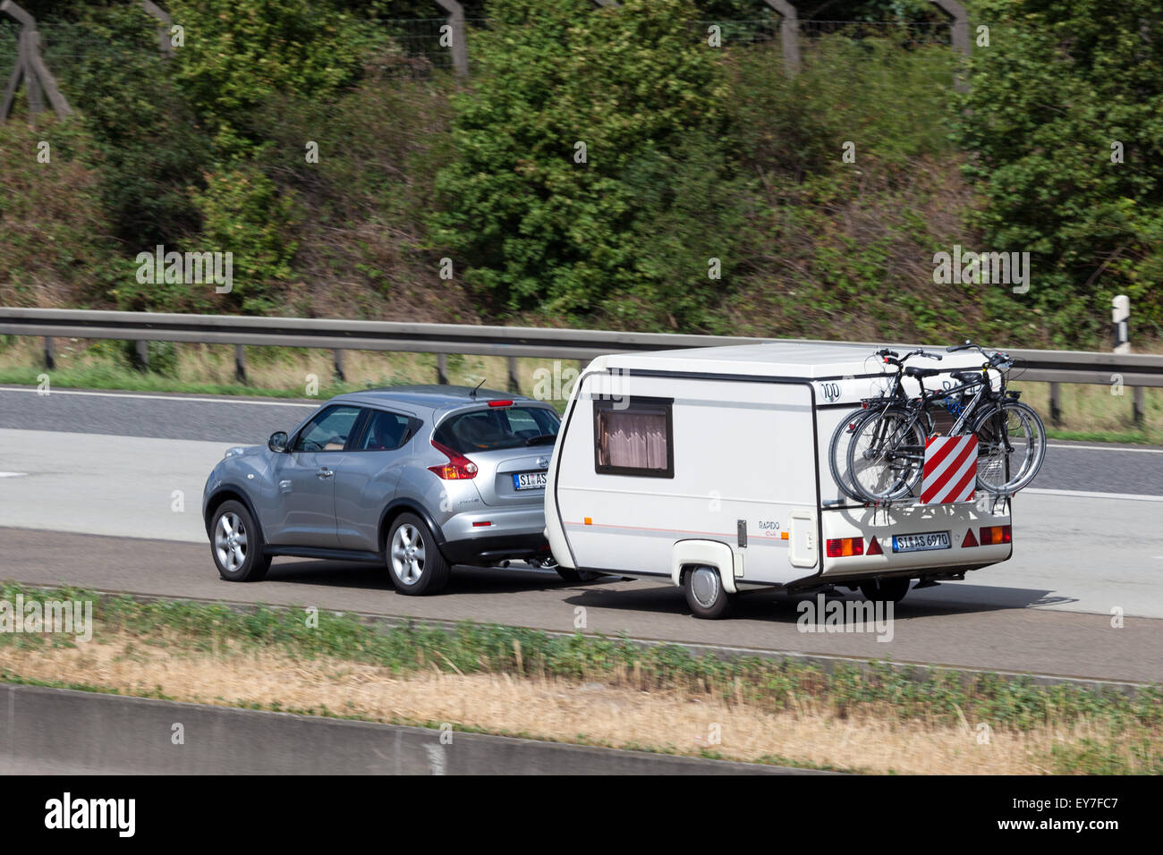 Nissan Juke avec avec une petite caravane voyageant à l'autoroute A5 en Allemagne Banque D'Images