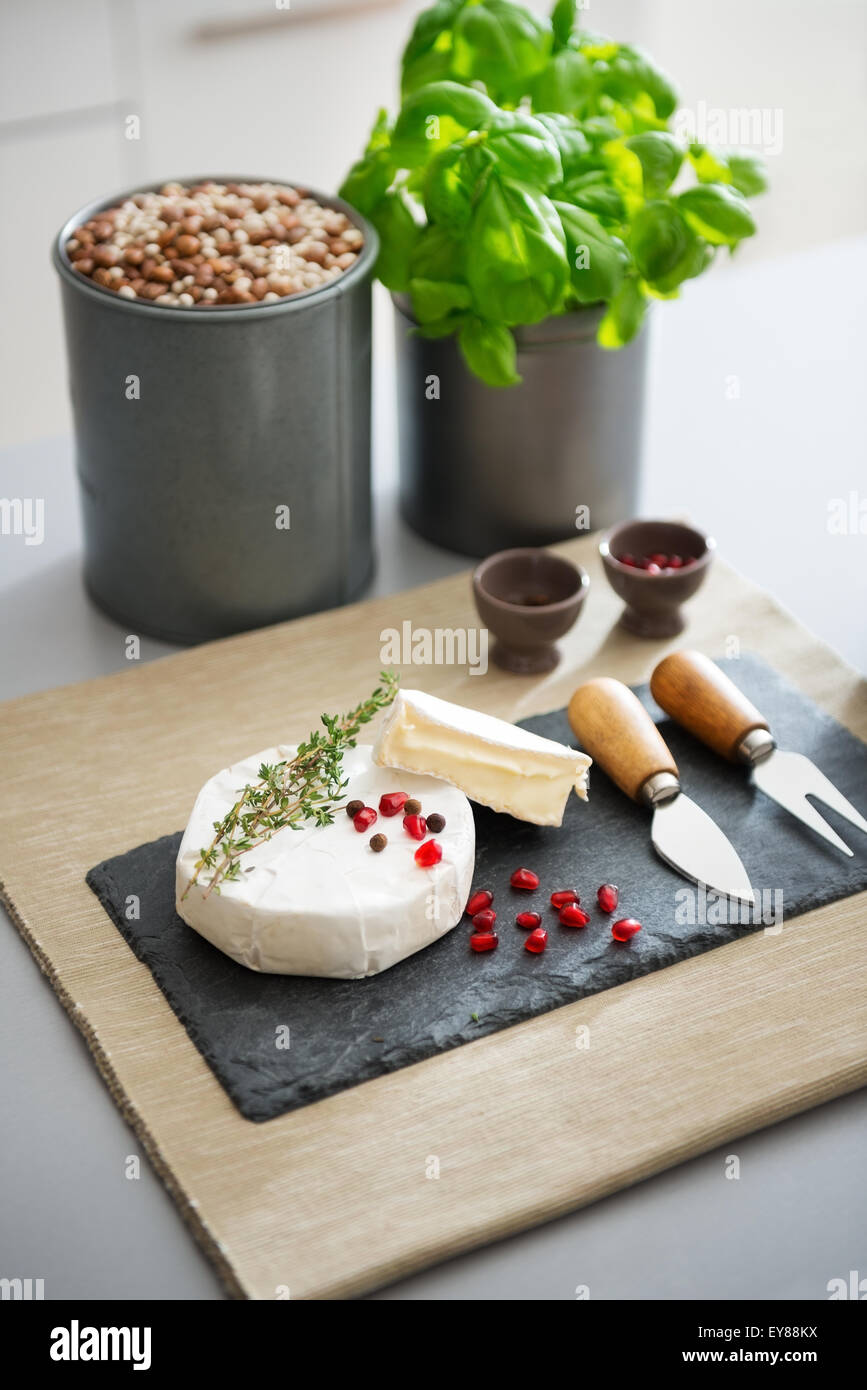 Le goût de la France, il y a droit à un conseil. Un Frais, parfait le camembert est prêt à être pris sur une liste de sélection. Il est décoré avec du romarin frais et graines de grenade. Banque D'Images