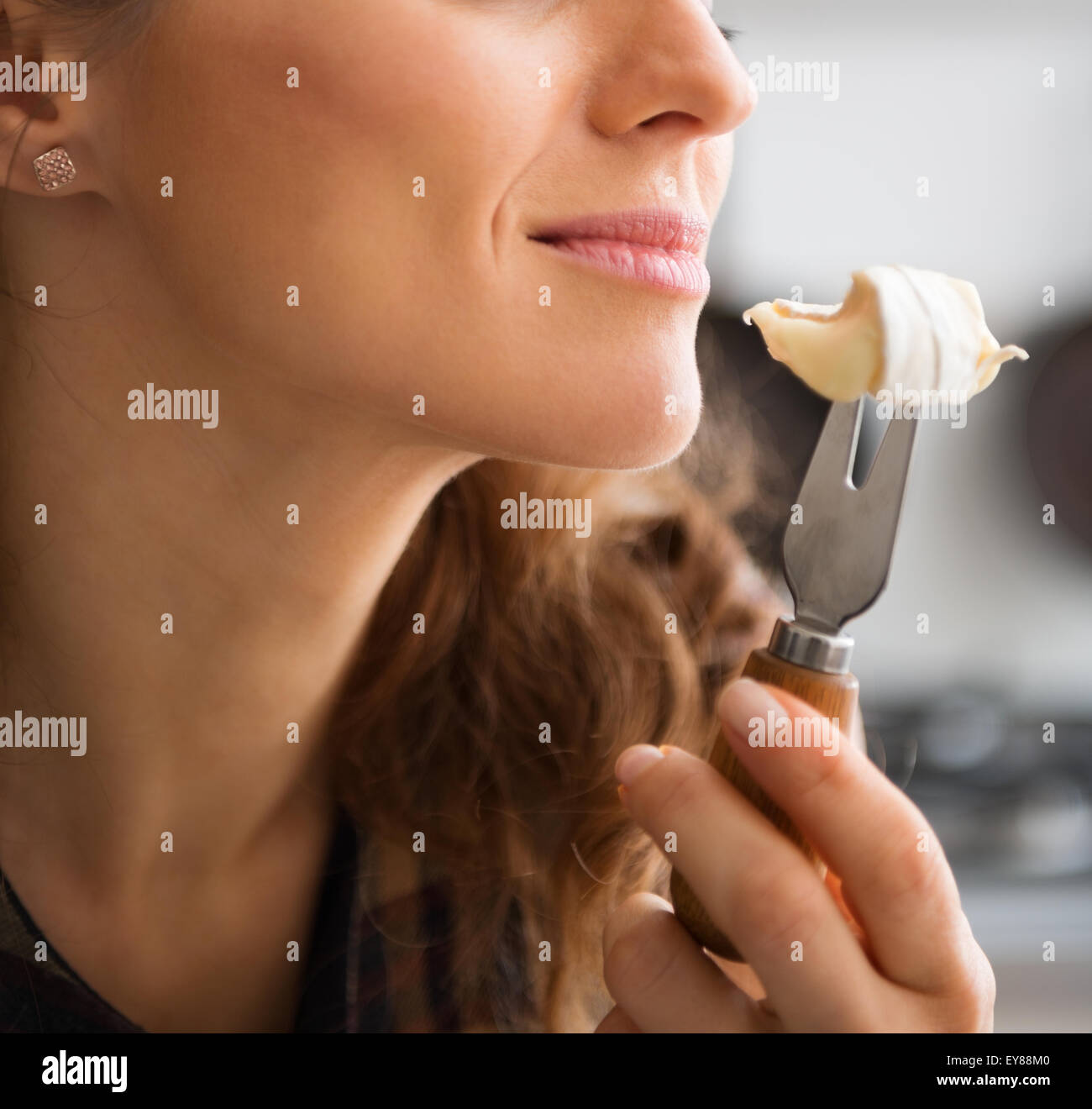 Oh, l'arôme riche d'un camembert mûr. Il n'y a pas d'erreur, c'est que l'odeur enivrante et goût merveilleux. Ici, nous voyons une femme qui sent la forte odeur du fromage la elle est sur le point de manger. Banque D'Images