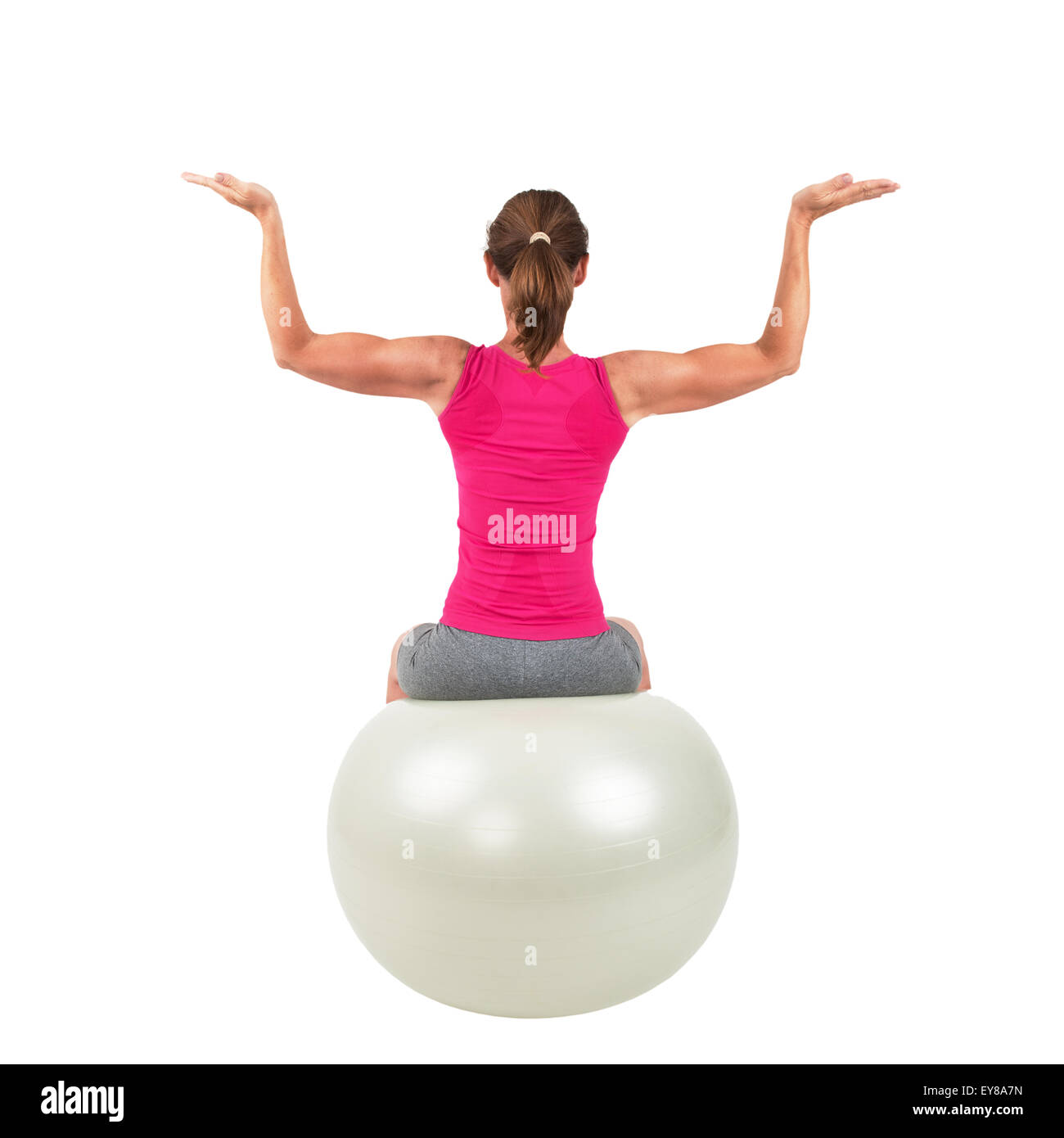 Femme sportive assis sur un ballon de gymnastique et d'entraînement à faire Banque D'Images