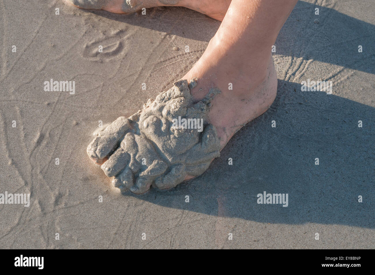 Personne jouant dans le sable sur une plage dans le Strand, Afrique du Sud au coucher du soleil Banque D'Images