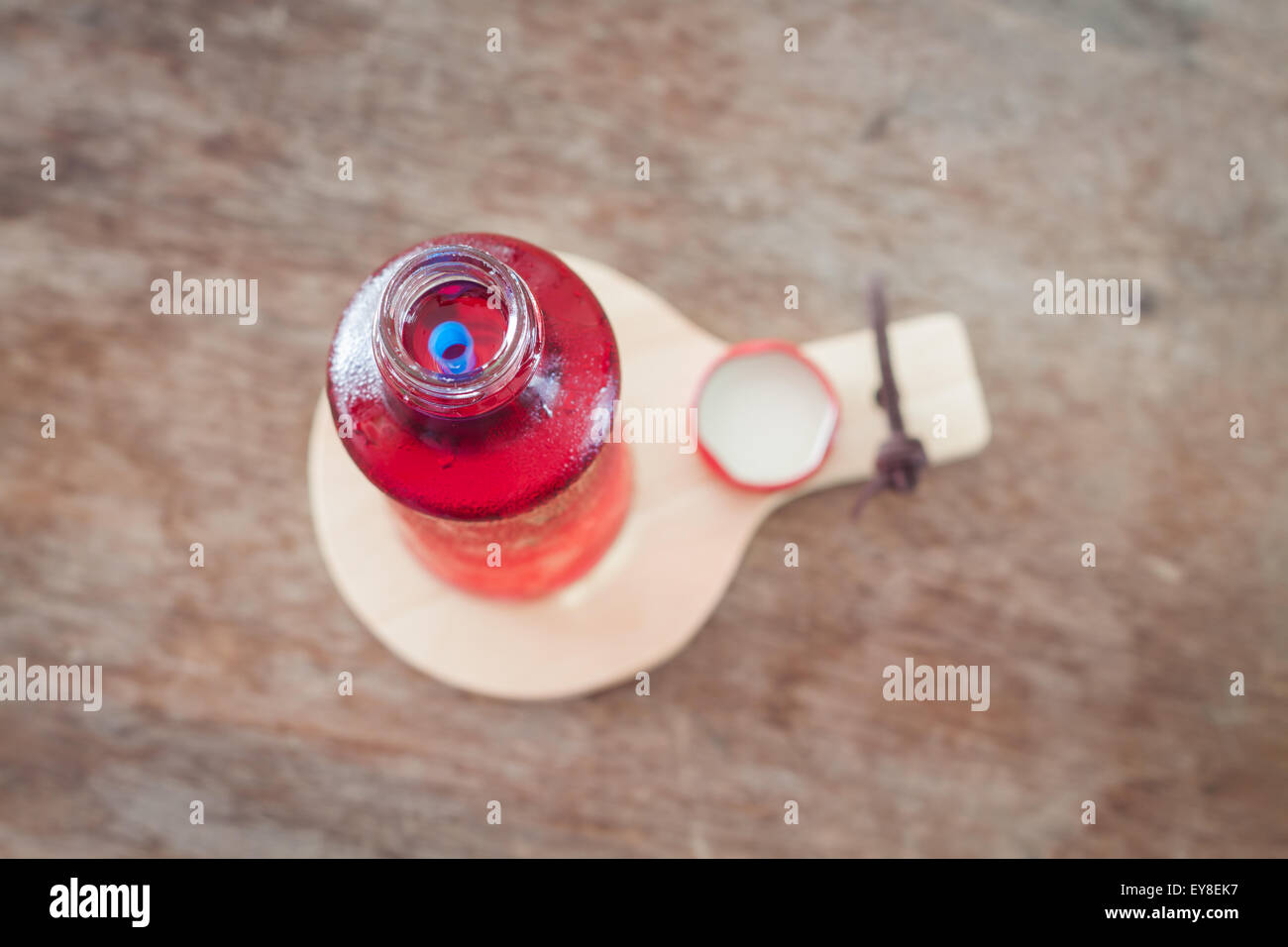 Dans la bouteille de sirop rouge sur plaque de bois, stock photo Banque D'Images