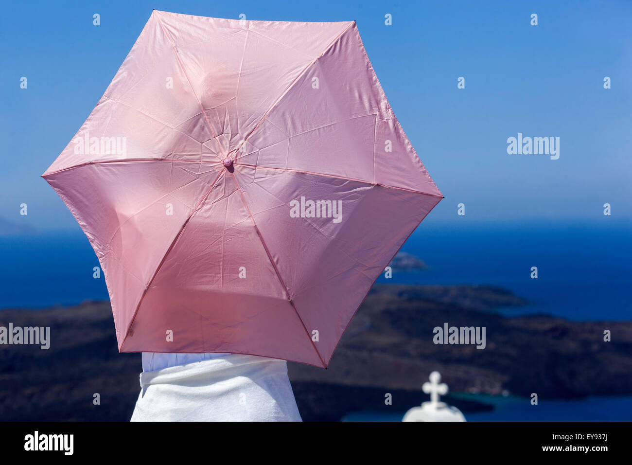 Femme et un parapluie rose, terrasse, Santorini, Îles Cyclades, Grèce, Europe Banque D'Images