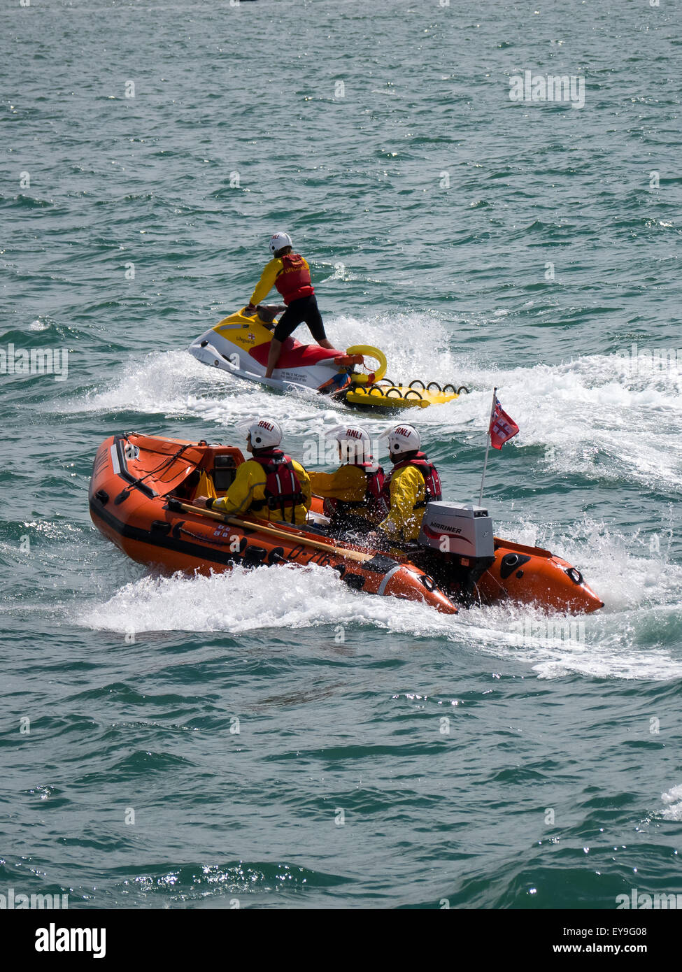 Les sauveteurs RNLI équitation une côte et un scooter dans la mer Banque D'Images