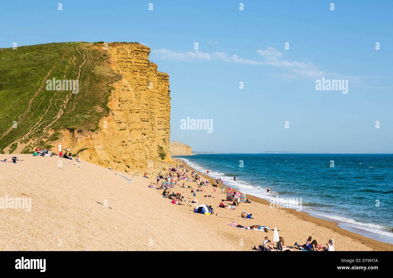 Plage de sable et de hautes falaises jaune doré de West Bay, sur la côte jurassique, Dorset, au sud-ouest de l'Angleterre, en été Banque D'Images