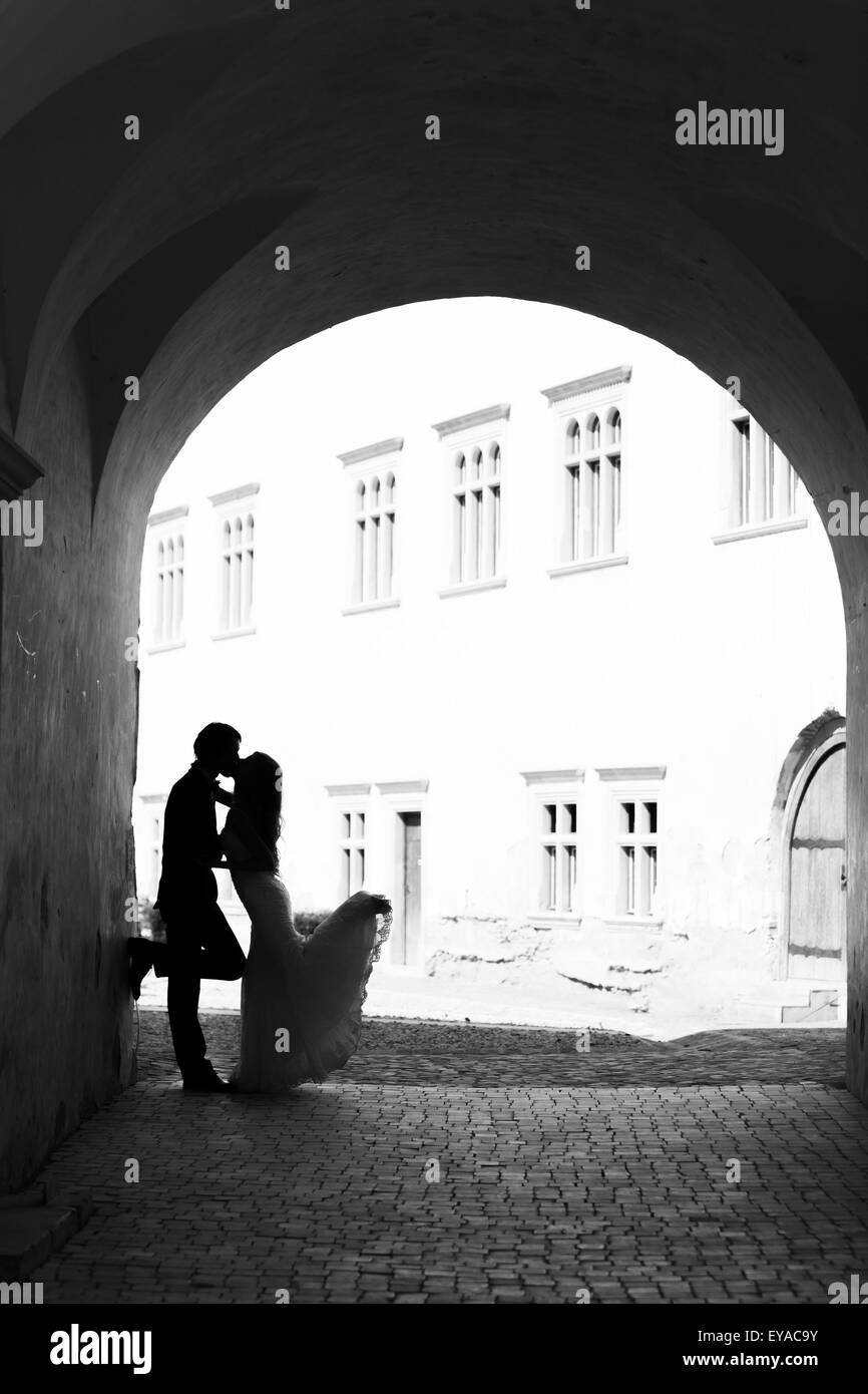 Couple de s'embrasser dans un couloir. Image en noir et blanc avec du grain ajouté comme effet. Banque D'Images