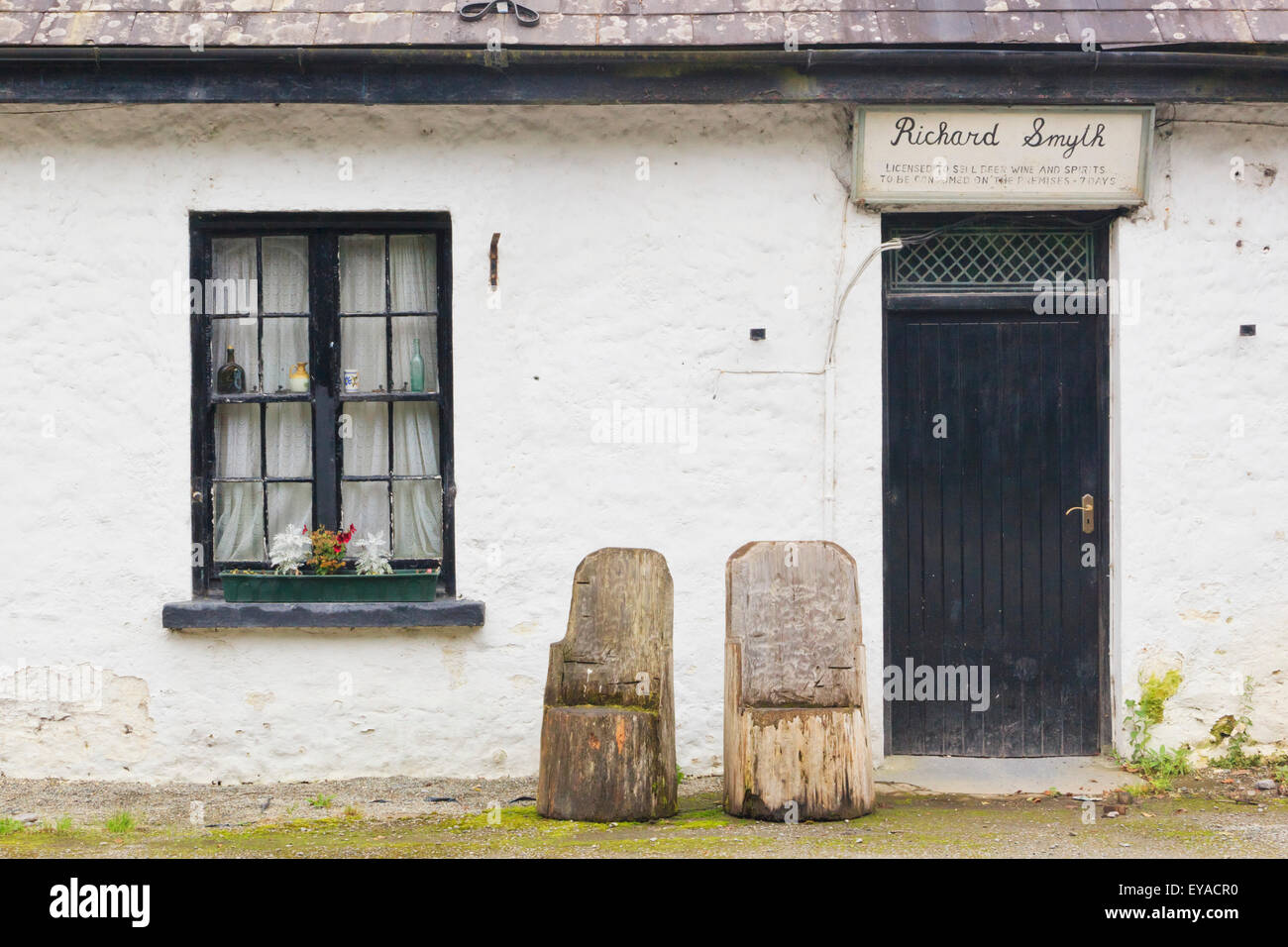 Avant de Richard Smyth's Pub avec des chaises sculptées à la main à partir de billes de bois dans La Healy Pass ; County Kerry, République d'Irlande Banque D'Images