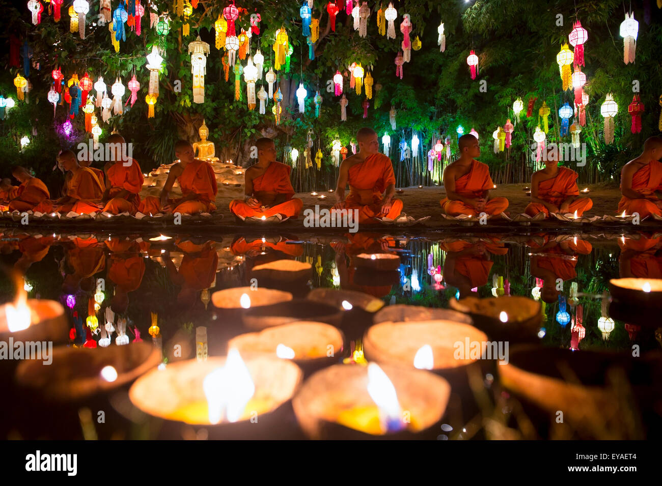 CHIANG MAI, THAÏLANDE - 06 NOVEMBRE 2014 : Bougies flotter en face de jeunes moines bouddhistes méditant dans un festival de lumières. Banque D'Images