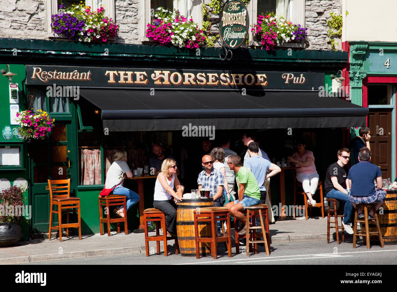 Les clients assis à des tables à l'extérieur du fourreau d'un pub, Kenmare, comté de Kerry, Irlande Banque D'Images